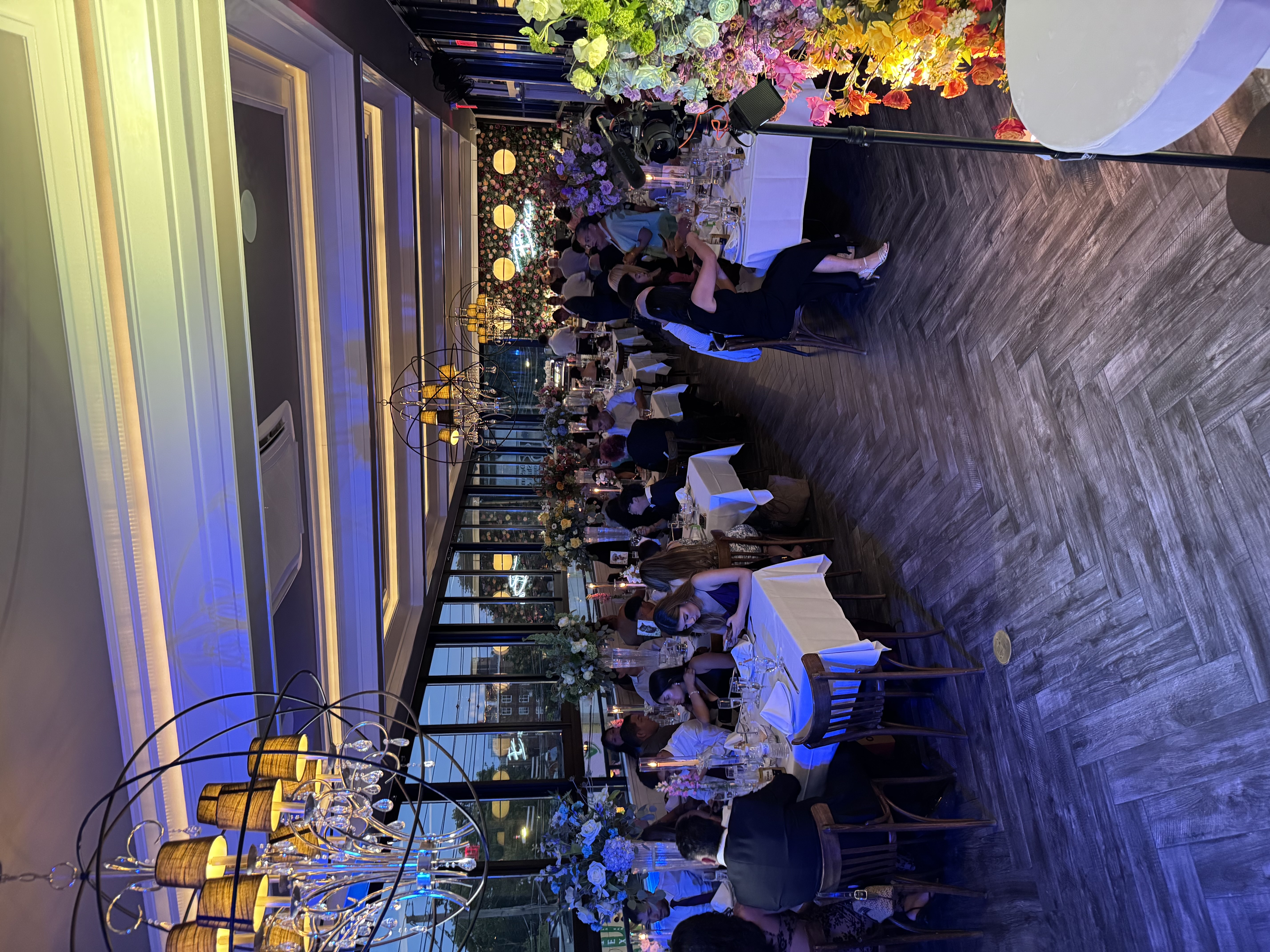 The Rooftop dining room looking toward the flower-wall bar and Baci neon sign